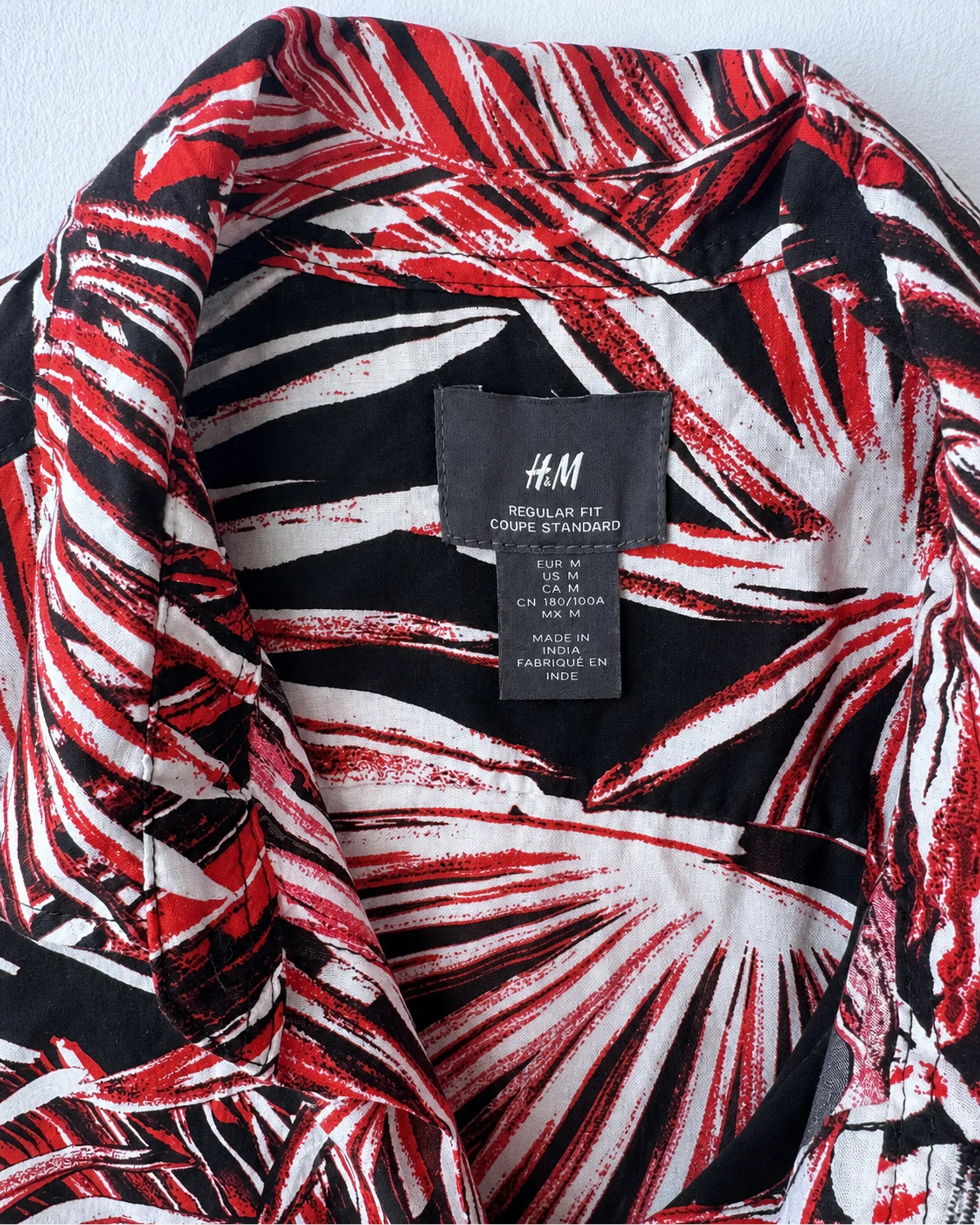 Etiqueta original de marca y talla de camisa o top h&m rojo, negro y blanco talla m