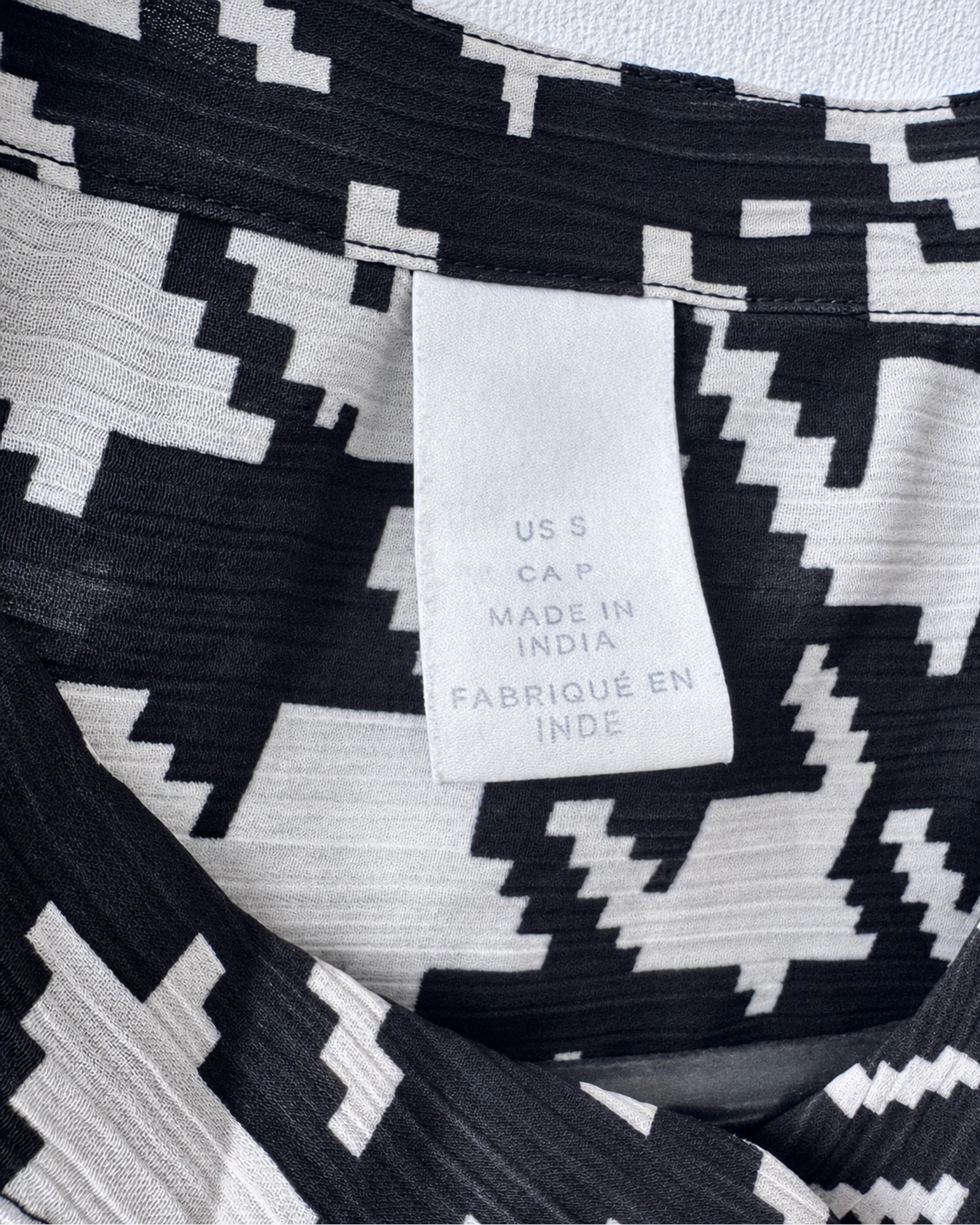 Etiqueta original de marca y talla de camisa o top negro, crema y blanco talla us s / ca p