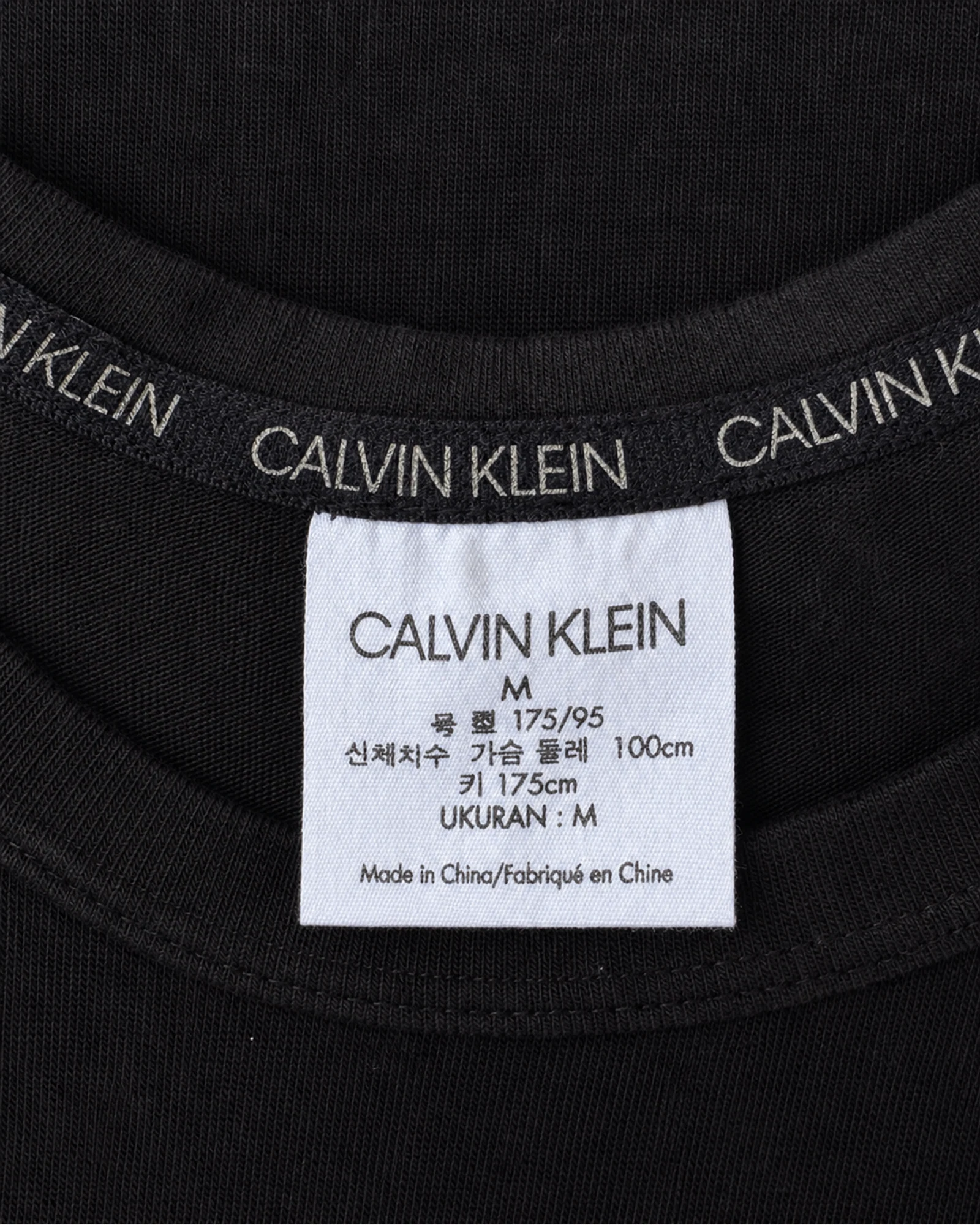 Etiqueta original de marca y talla de camisa o top calvin klein negro y tan talla m