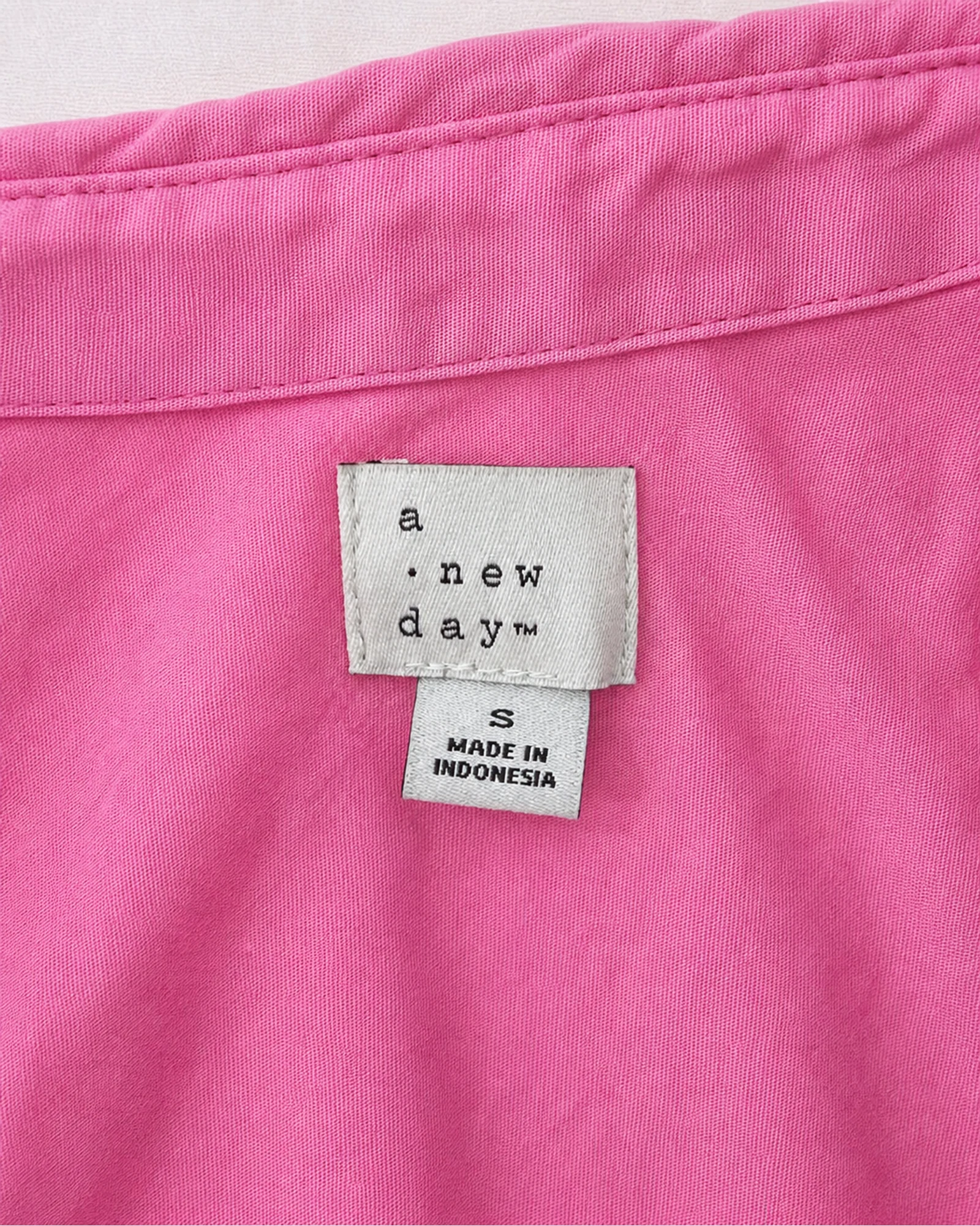 Etiqueta original de marca y talla de camisa o top a new day rosado talla s