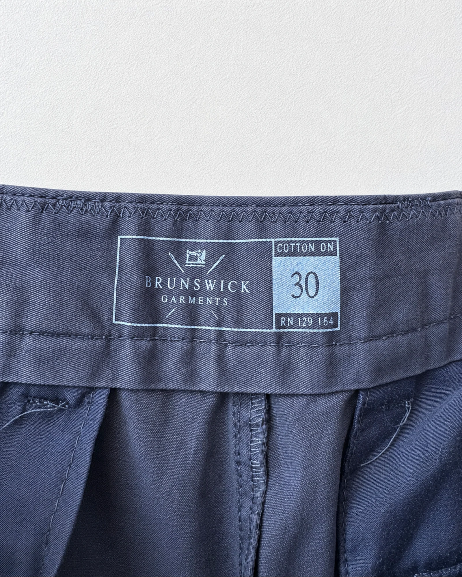 Etiqueta original de marca y talla de short brunswick garments gris y azul talla 30