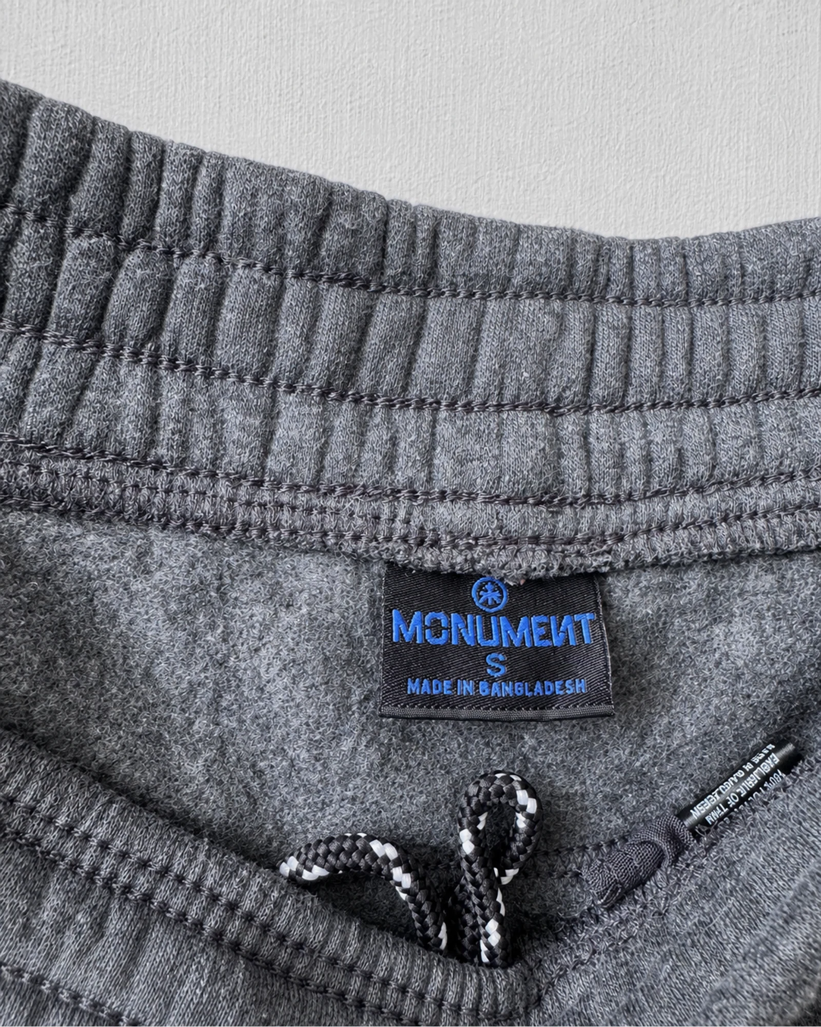Etiqueta original de marca y talla de short monument gris talla s