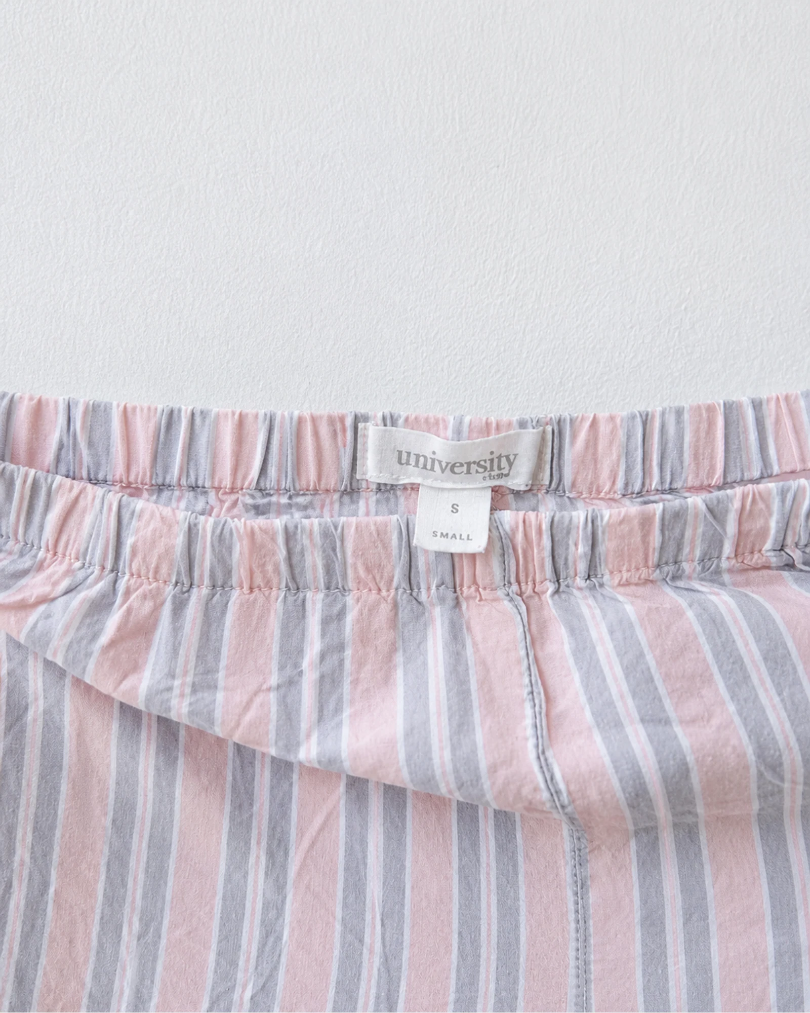 Etiqueta original de marca y talla de pantalón burberry rosado, blanco y gris talla s